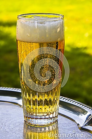 A glass of beer silver on a tray