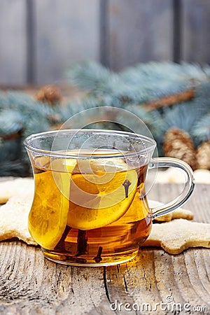 Glass of hot steaming tea among christmas decorations
