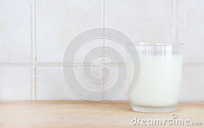 A glass of milk on a wooden chopping board
