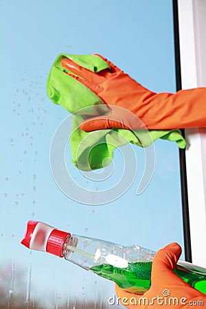 Gloved hand cleaning window rag and spray