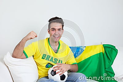 Goal celebrations of a brazilian soccer fan at sofa
