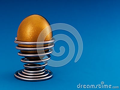 Gold, golden egg in eggcup - nest egg, investment concept