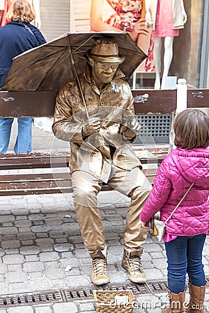 Gold man show a little girl