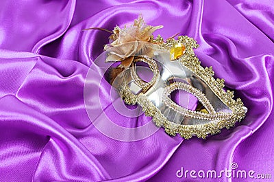 Gold mask on purple silk fabric