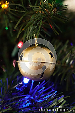 Gold Sleigh Bell Ornament Hung on an Artificial Christmas Tree