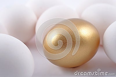 Golden egg and jast eggs on a white