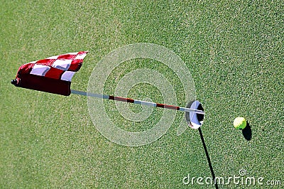 Golf ball near hole and flag