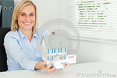 Gorgeous businesswoman presenting model house