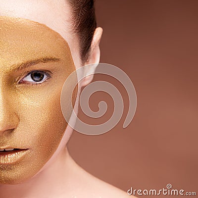 Gorgeous girl with gold face make up