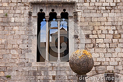 Gothic window on the ancient stone wall with refle