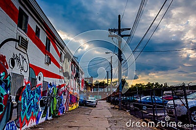 Graffiti and parked cars in an alley at sunset in Baltimore, Mar