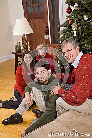Grandfather with family sitting by Christmas tree