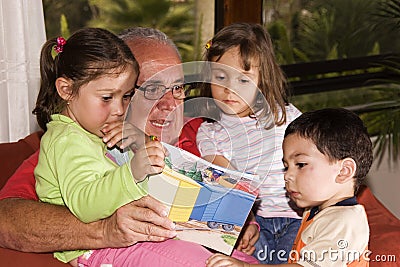 Grandfather and grandchildren reading together