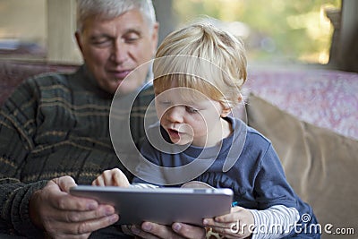 Grandfather and grandson using Tablet PC