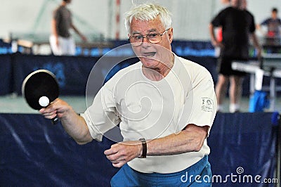 Grandfather senior plays table tennis