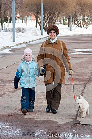 Grandmother with granddaughter and dog on walk