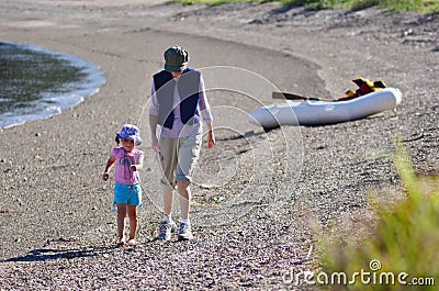 Grandmother and her grandchild walks on the beach