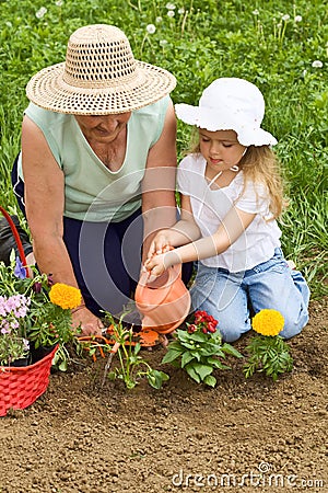 Grandmother teaching child the basics of gardening