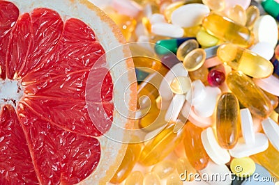 Grapefruit and pills, vitamin supplements on white background, healthy diet concept