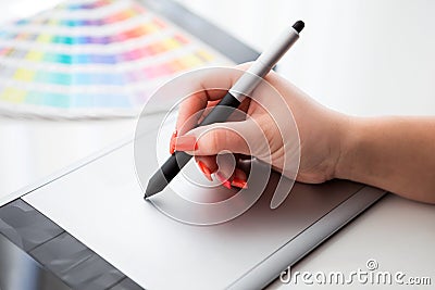Graphic designer working on a digital tablet and with palette
