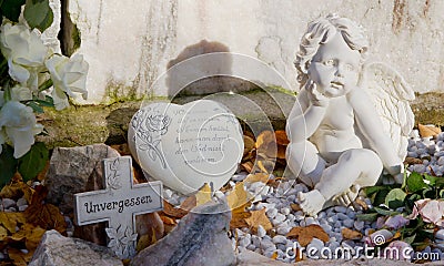 Grave with cross, heart and angels and german text