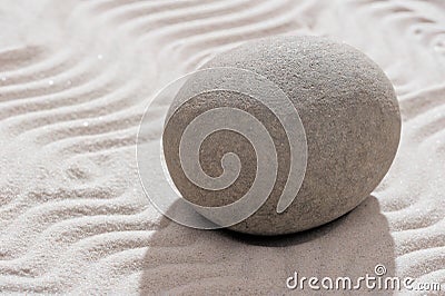 Gray smooth stone in garden on the sand