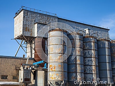 Gray tall tanks on old concrete factory