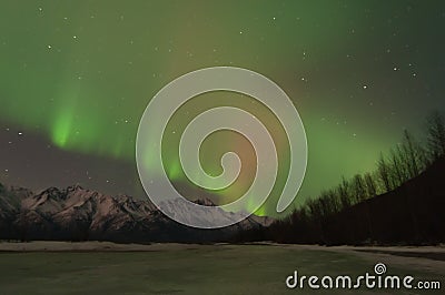 Green Aurora Over Mountains And A Frozen Lake