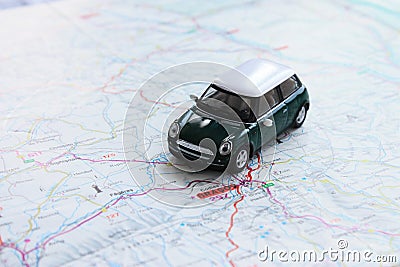 Green miniature car on paper map