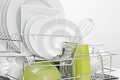 Green and white dishes drying on dish rack