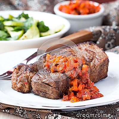 Grilled beef steak with salsa sauce dried tomatoes, red peppers