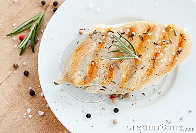 Grilled chicken breast with rosemary on white plate