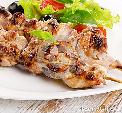 Grilled chicken kebab on a white plate