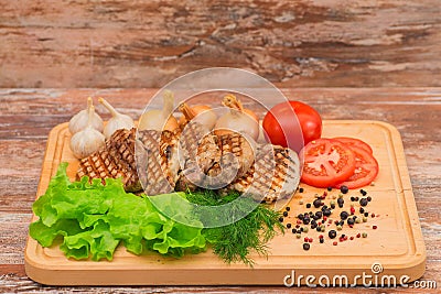 Grilled steak with vegetables on a wooden board