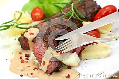 Grilled strip steak with tomato and salad