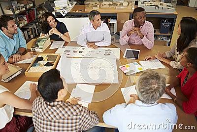 Group Of Architects Sitting Around Table Having Me