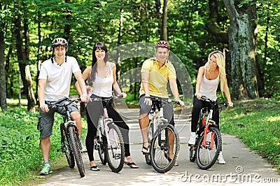 Group of attractive happy people on bicycles in the countryside