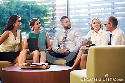 Group Of Businesspeople Having Meeting In Office Lobby