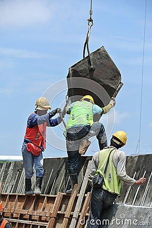 Group of construction workers casting concrete wall