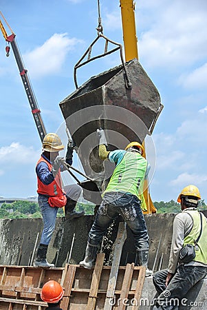 Group of construction workers casting concrete wall