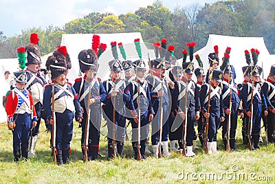 A group of French (Napoleonic) soldiers-reenactors standing in a row.