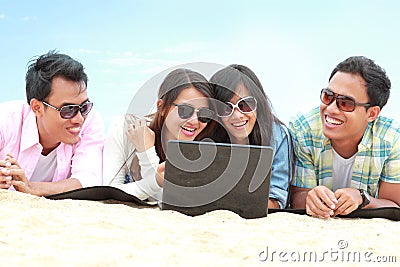 Group Friends Enjoying Beach Holiday together with laptop