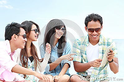 Group Friends Enjoying Beach Holiday together with tablet pc