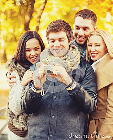 Group of friends with photo camera in autumn park