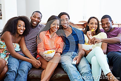 Group Of Friends Sitting On Sofa Watching TV Together