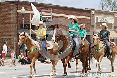 Group of 4H riders on horseback in a parade in small town America