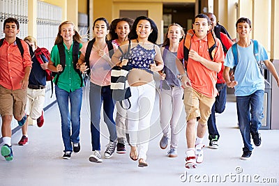 Group Of High School Students Running Along Corridor