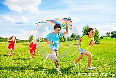 Group of kids run with kite