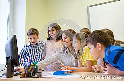 Group of kids with teacher and computer at school