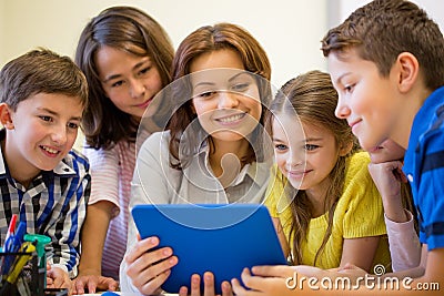 Group of kids with teacher and tablet pc at school